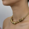 Gedraaide gouden stijve ketting van roestvrij staal – Modern en sculpturaal design.