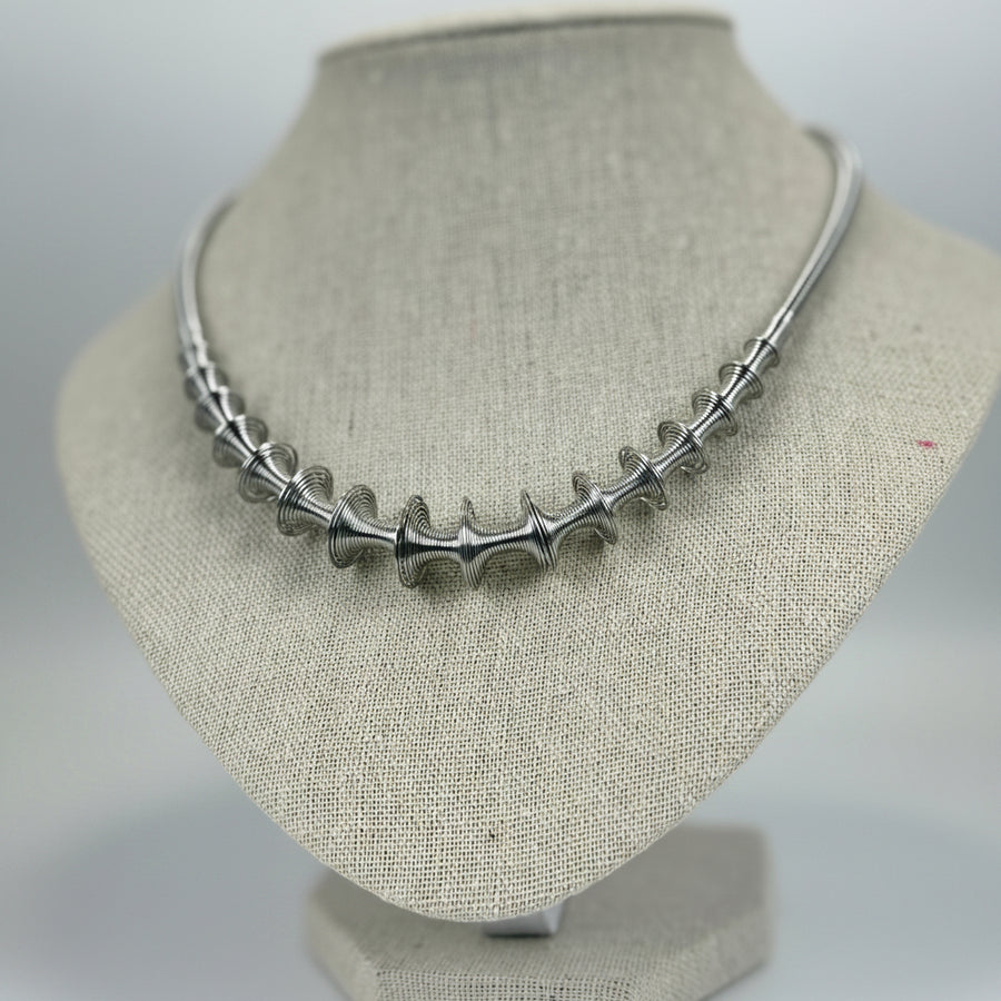 Starre, silberfarbene Halskette im Design aus gedrehtem Edelstahl – Verstellbar und modern.