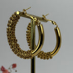 Goldfarbene Creolen aus Edelstahl mit Kettchen.