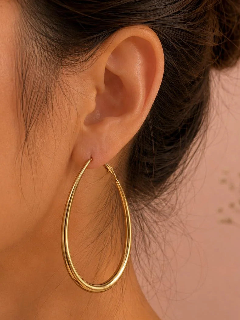 Gewellte Ohrringe aus goldfarbenem Edelstahl – Skulpturales Design und moderner Glanz.