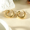 Gewellte Ohrringe aus goldfarbenem Edelstahl – Skulpturales Design und moderner Glanz.