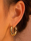 Gewellte Ohrringe aus goldfarbenem Edelstahl – Skulpturales Design und moderner Glanz.