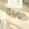 Gewellte Ohrringe aus goldfarbenem Edelstahl – Skulpturales Design und moderner Glanz.