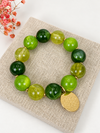 Armband mit grünen Perlen & goldfarbenem Medaillon – Natürliche und sonnige Eleganz