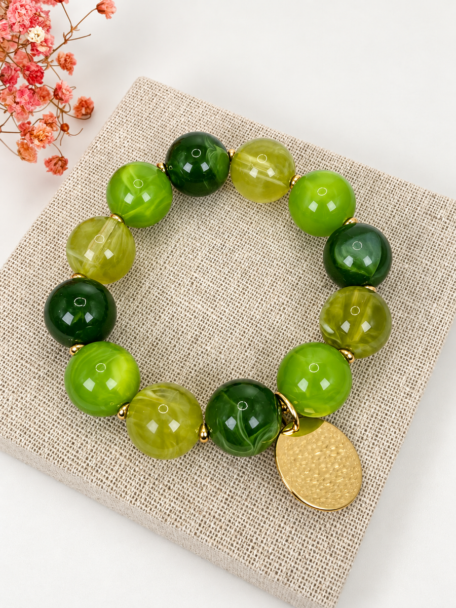 Armband mit grünen Perlen & goldfarbenem Medaillon – Natürliche und sonnige Eleganz