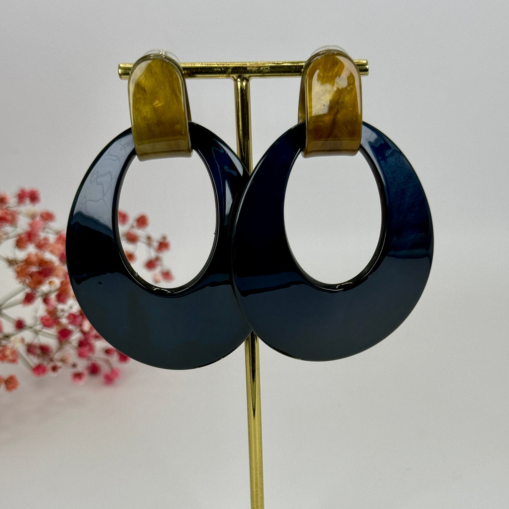 Ovale dunkelblaue Ohrhänger aus Kunstharz.
