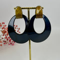 Ovale dunkelblaue Ohrhänger aus Kunstharz.