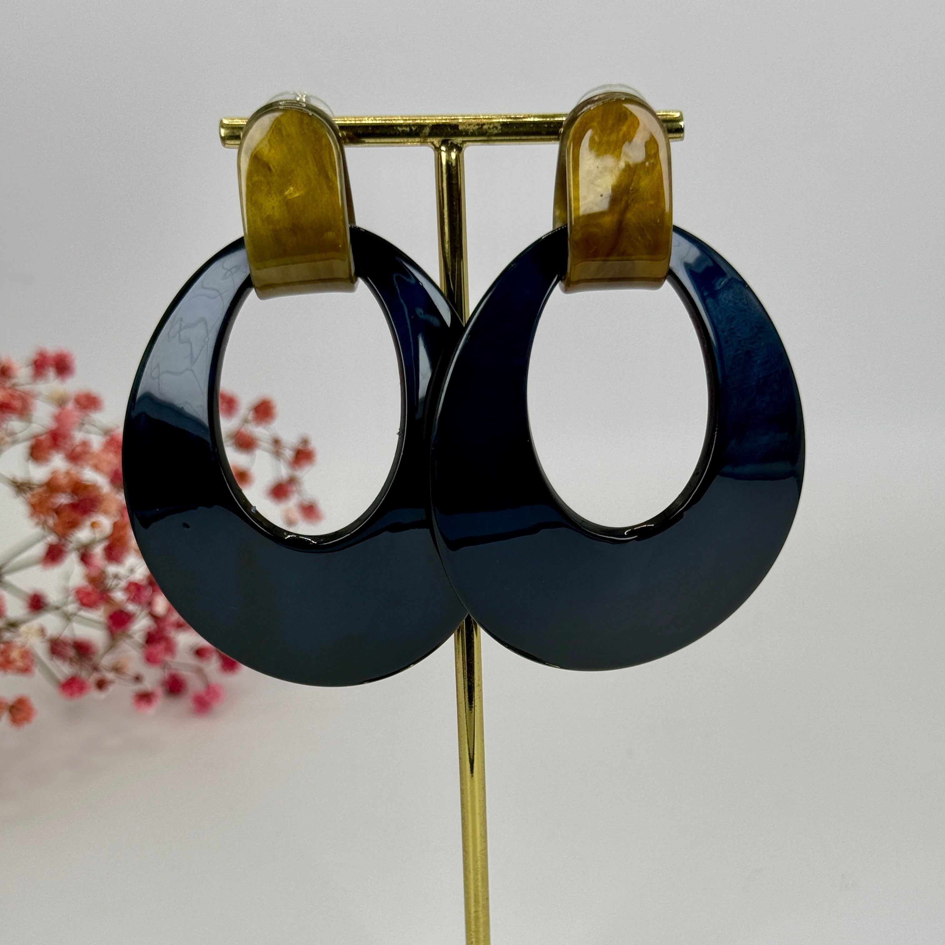 Ovale dunkelblaue Ohrhänger aus Kunstharz.