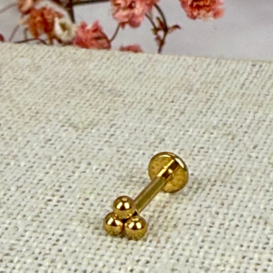 Piercing met drie balletjes - Goudkleurige oorstekers van roestvrij staal.