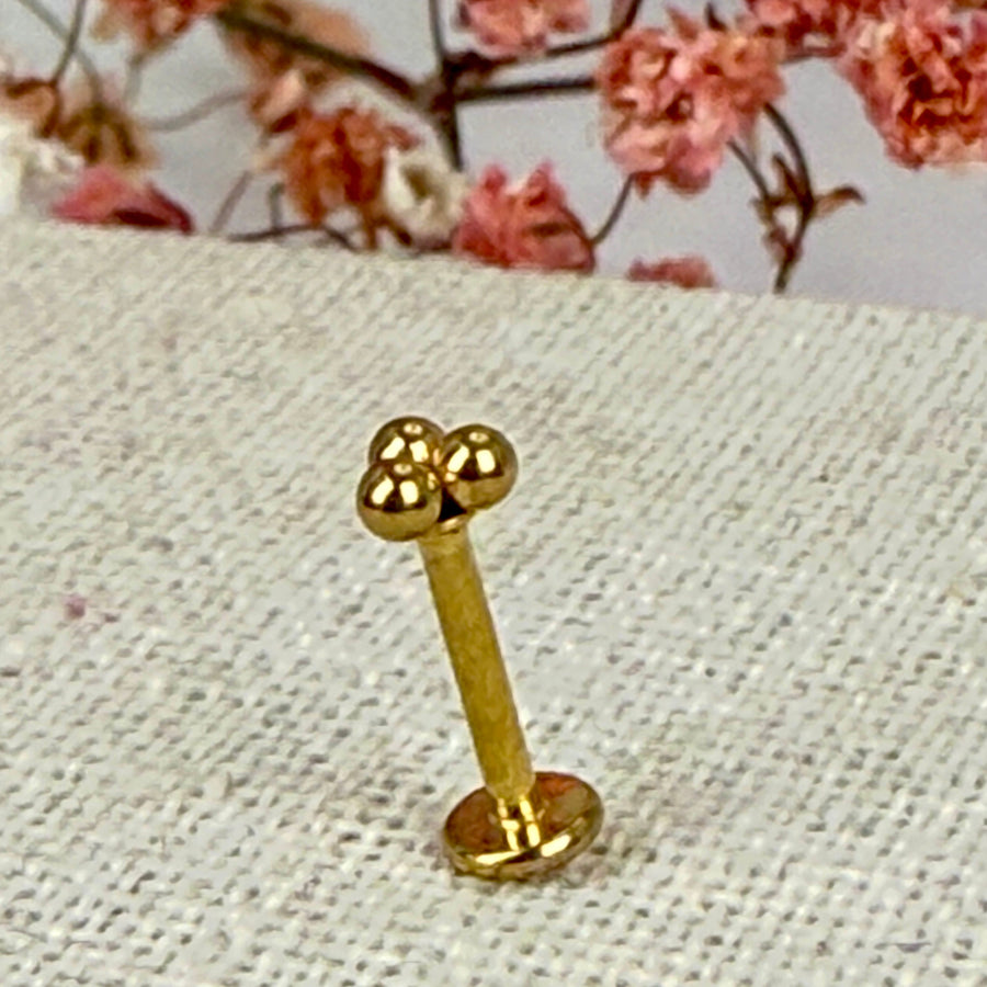 Piercing met drie balletjes - Goudkleurige oorstekers van roestvrij staal.