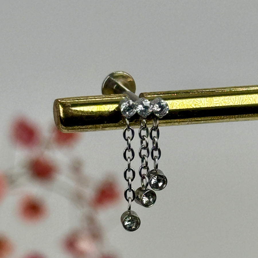 Ketten- und Zirkonia-Piercing – gold-/silberfarbener Edelstahlstecker mit Zirkonia.