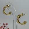 Gewellte Ohrringe aus goldfarbenem Edelstahl – Skulpturales Design und moderner Glanz.