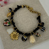 Armband Charm schwarzes vergoldetes Band – Perlen & Blumenanhänger