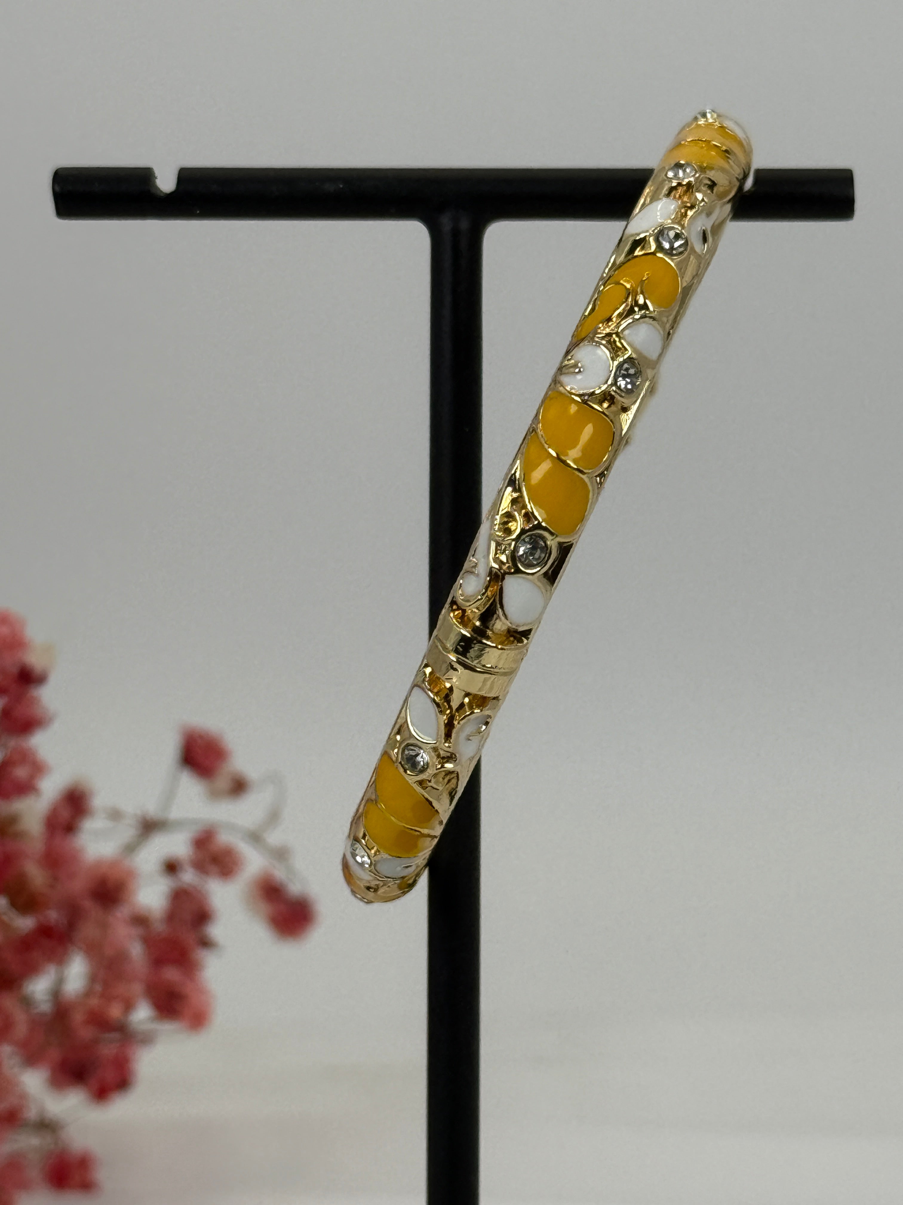 Open messing jasseronarmband met geëmailleerd geel en wit bloemenpatroon – binnendiameter 6 cm