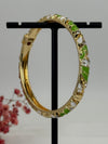 Bracelet jonc ouvrable en laiton doré motif floral émaillé vert et blanc – diamètre intérieur 6 cm.