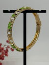 Bracelet jonc ouvrable en laiton doré motif floral émaillé vert et blanc – diamètre intérieur 6 cm.