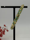 Öffnungsfähiger Armreif aus vergoldetem Messing mit grün und rosa emailliertem Blumenmuster – Innendurchmesser 6 cm.