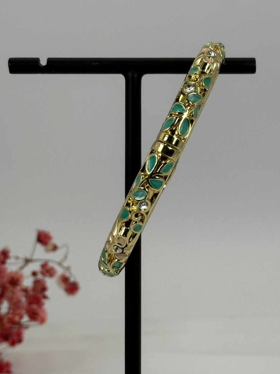 Öffnungsfähiger Armreif aus vergoldetem Messing mit grün und rosa emailliertem Blumenmuster – Innendurchmesser 6 cm.