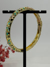 Öffnungsfähiger Armreif aus vergoldetem Messing mit grün und rosa emailliertem Blumenmuster – Innendurchmesser 6 cm.