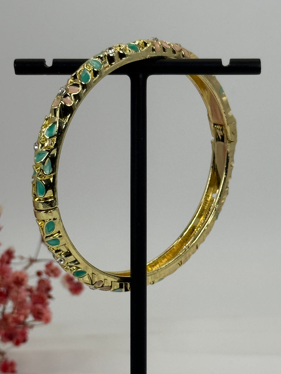 Öffnungsfähiger Armreif aus vergoldetem Messing mit grün und rosa emailliertem Blumenmuster – Innendurchmesser 6 cm.