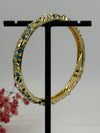 Armreif, aufklappbar, aus vergoldetem Messing, emailliertes Blumenmotiv in Blau (1) und Weiß – Innendurchmesser 6 cm.