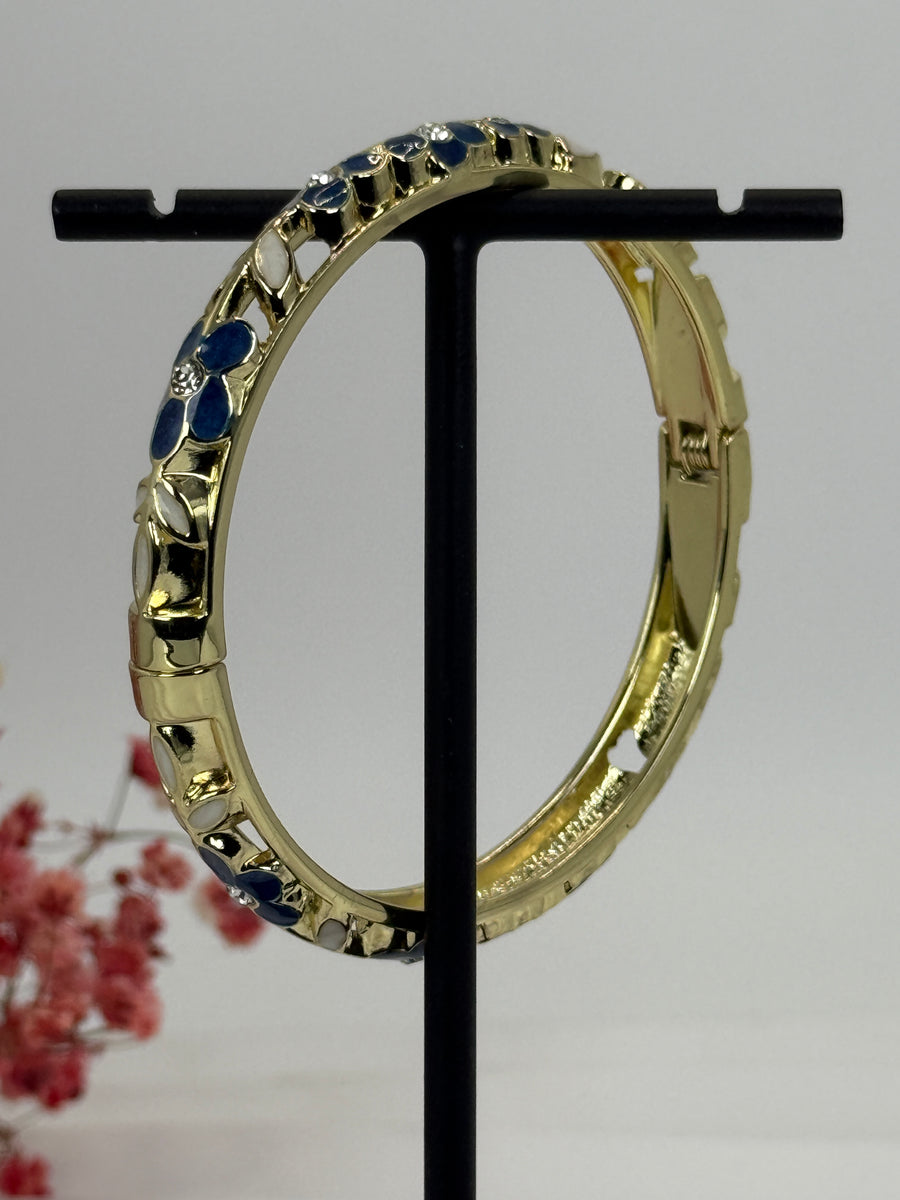 Aufklappbarer Armreif aus vergoldetem Messing mit floralem Muster in blauem (3) und weißem Emaille – Innendurchmesser 6 cm.