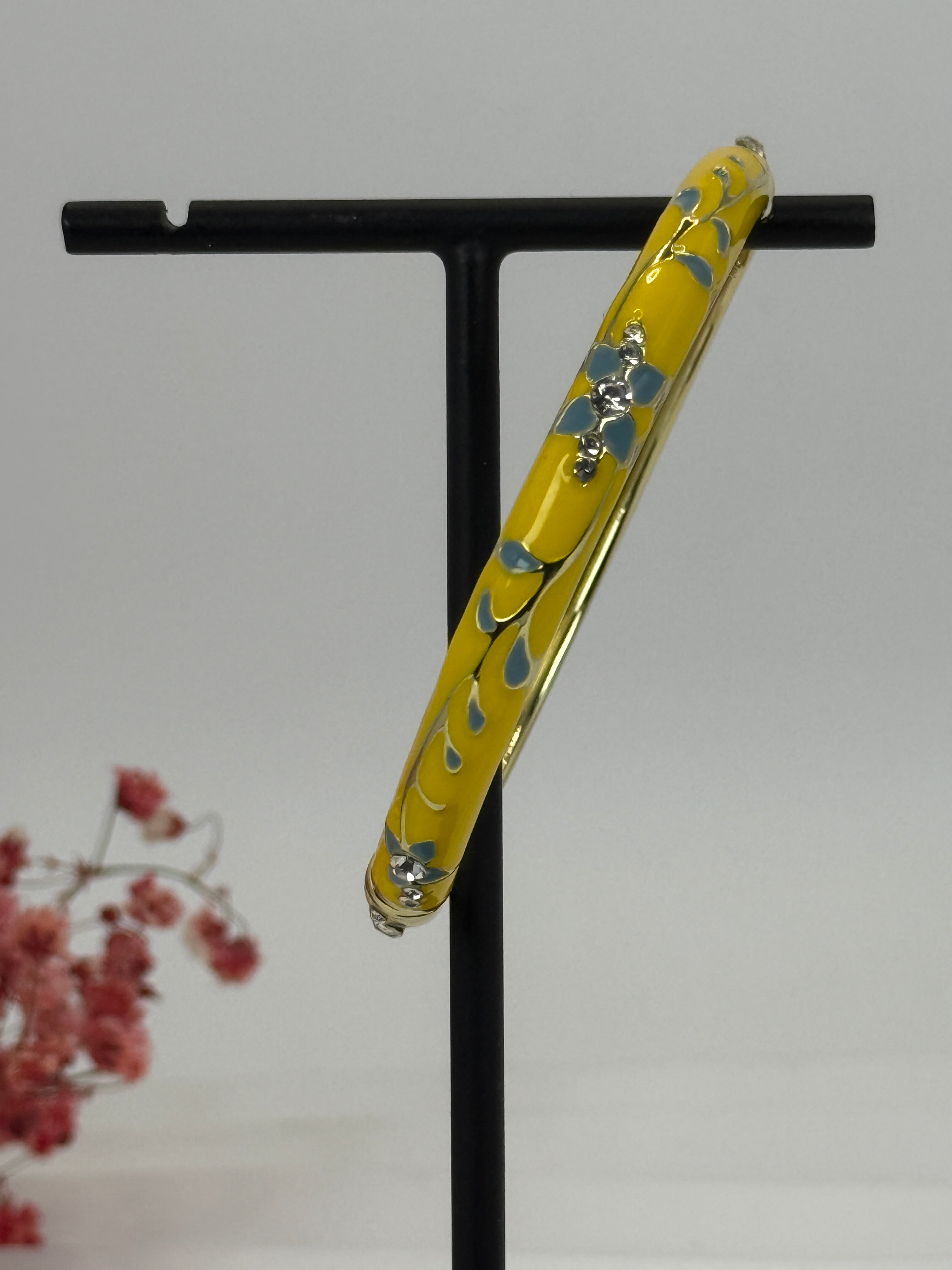 Goudkleurige opvouwbare messing armband met geëmailleerd geel bloemmotief - binnendiameter 6 cm