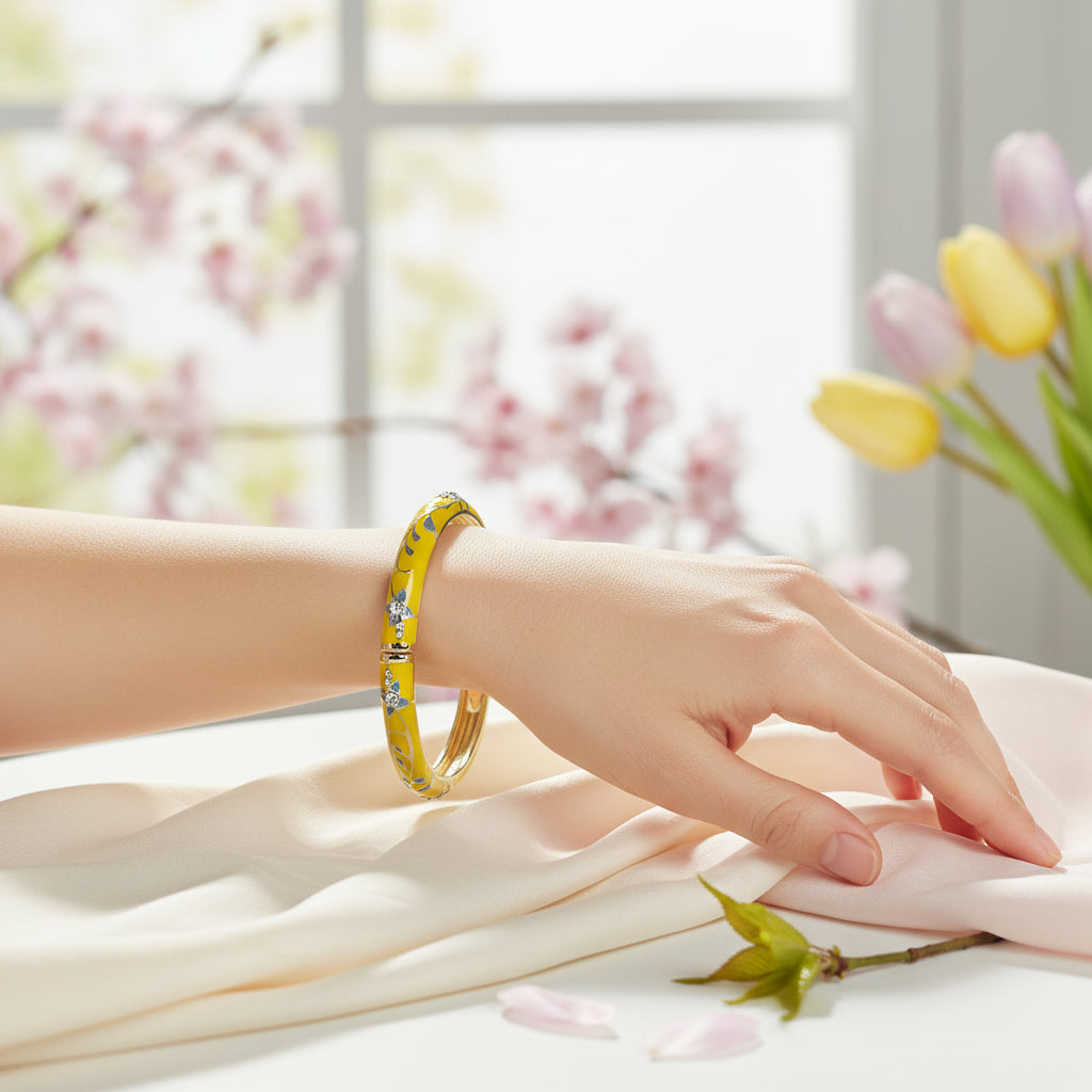 Goudkleurige opvouwbare messing armband met geëmailleerd geel bloemmotief - binnendiameter 6 cm
